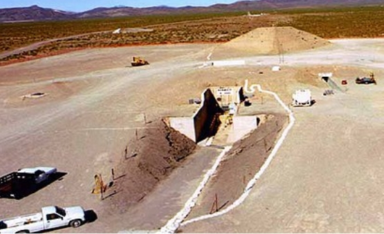A bird's eye view of structures on the ground in a desert like environment.